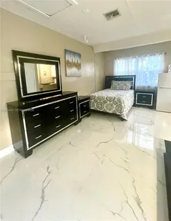 a bedroom with a bed and a tv on the wall