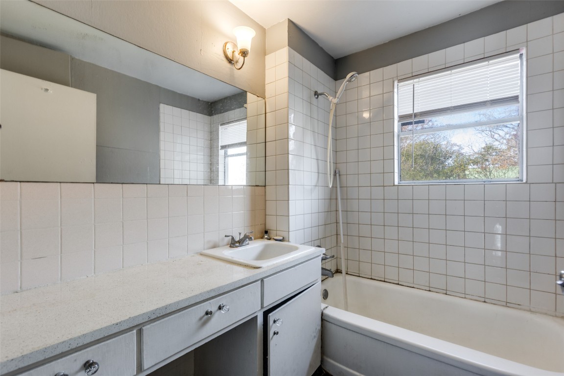 705 Campbell Street Lockhart, TX 78644 - Photo 16 of 30 a bathroom with a tub a sink and mirror