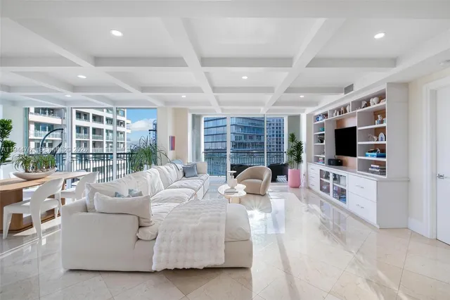 a living room with furniture a flat screen tv and a large window