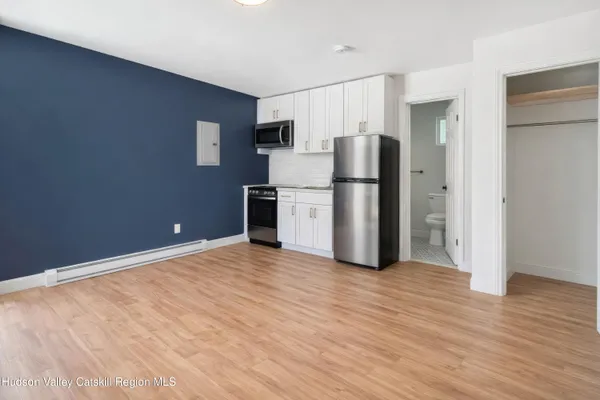 a view of kitchen with refrigerator cabinets and wooden floor