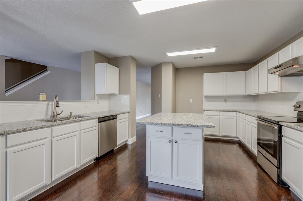 a kitchen with granite countertop white cabinets and white appliances