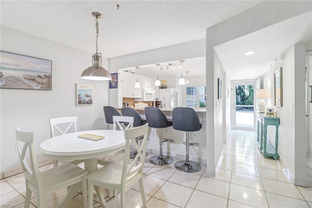 5675 Whitaker Road, Unit B101 Naples, FL 34112 - Photo 15 of 45 a view of a dining room and chairs