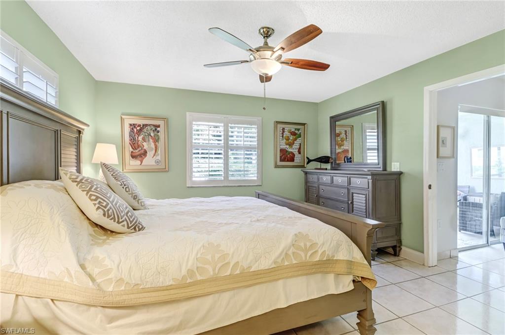 5675 Whitaker Road, Unit B101 Naples, FL 34112 - Photo 20 of 45 a bedroom with a large bed and a chandelier