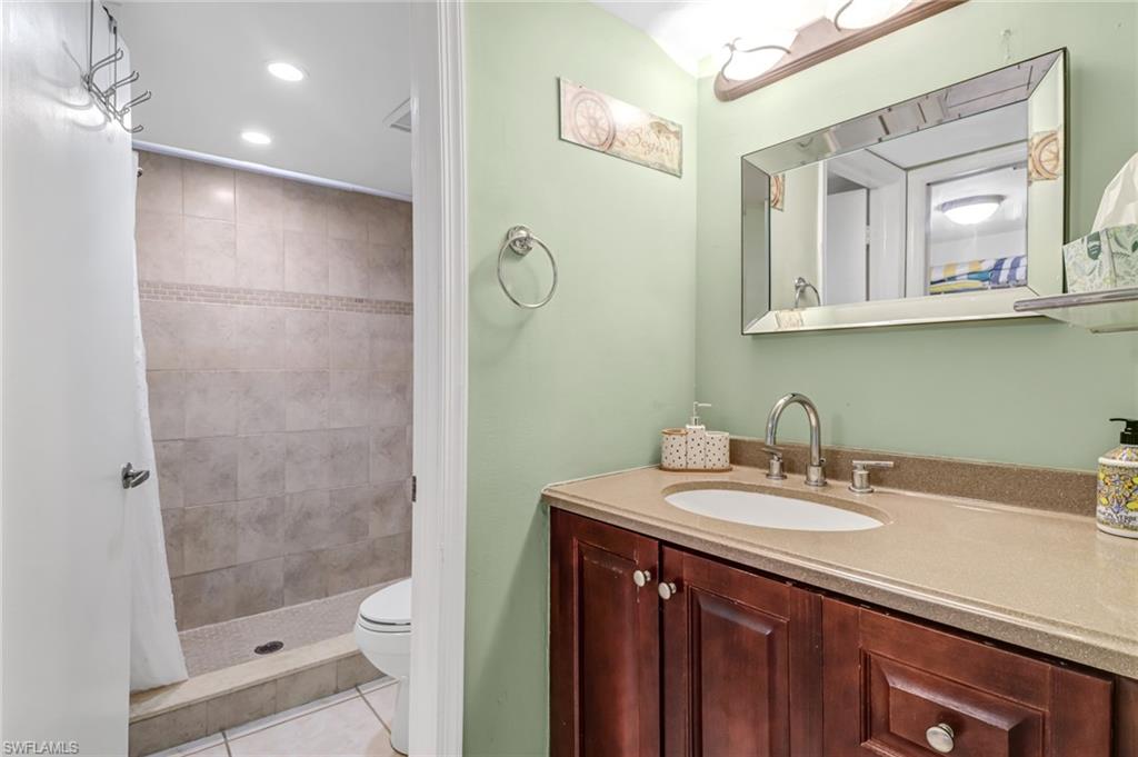 5675 Whitaker Road, Unit B101 Naples, FL 34112 - Photo 22 of 45 a bathroom with a sink a toilet and shower