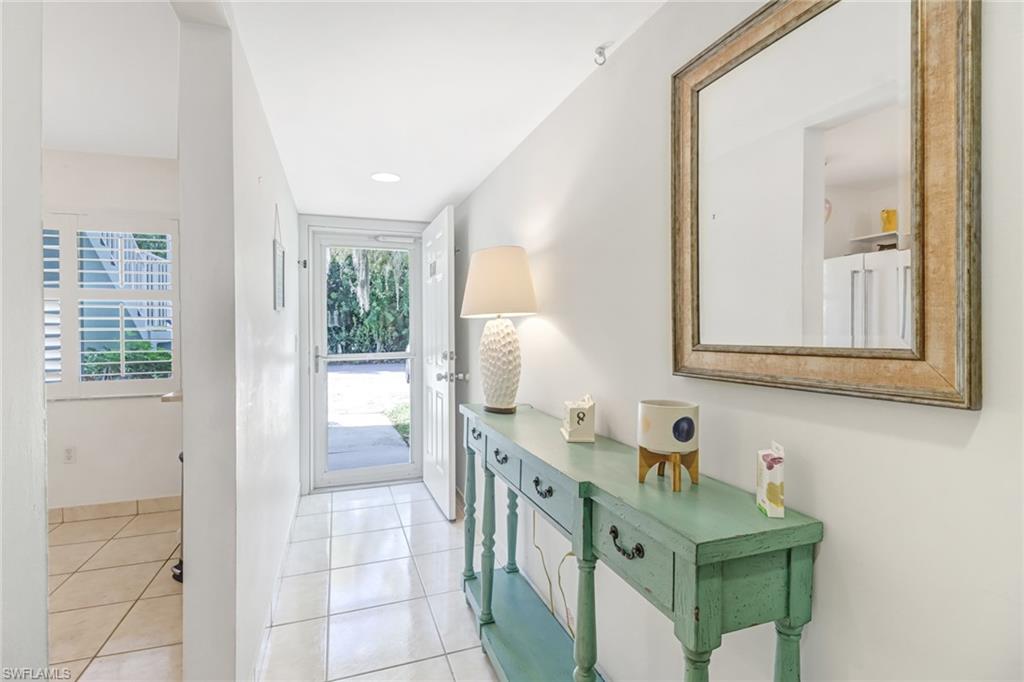 5675 Whitaker Road, Unit B101 Naples, FL 34112 - Photo 4 of 45 a bathroom with a sink a toilet and mirror
