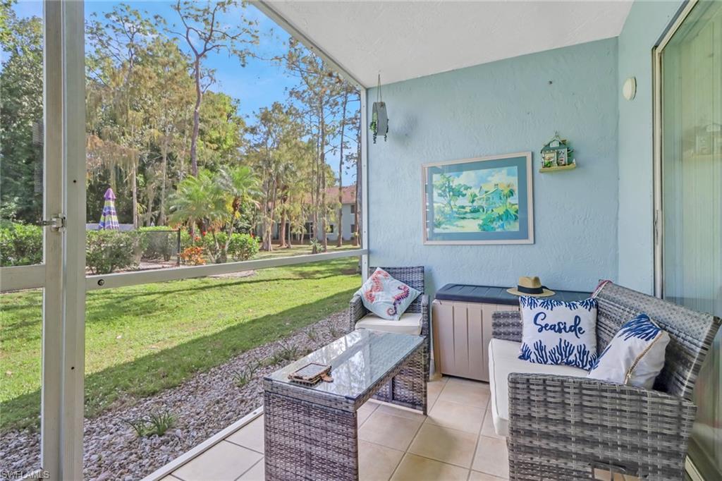 5675 Whitaker Road, Unit B101 Naples, FL 34112 - Photo 6 of 45 a living room with furniture and a garden