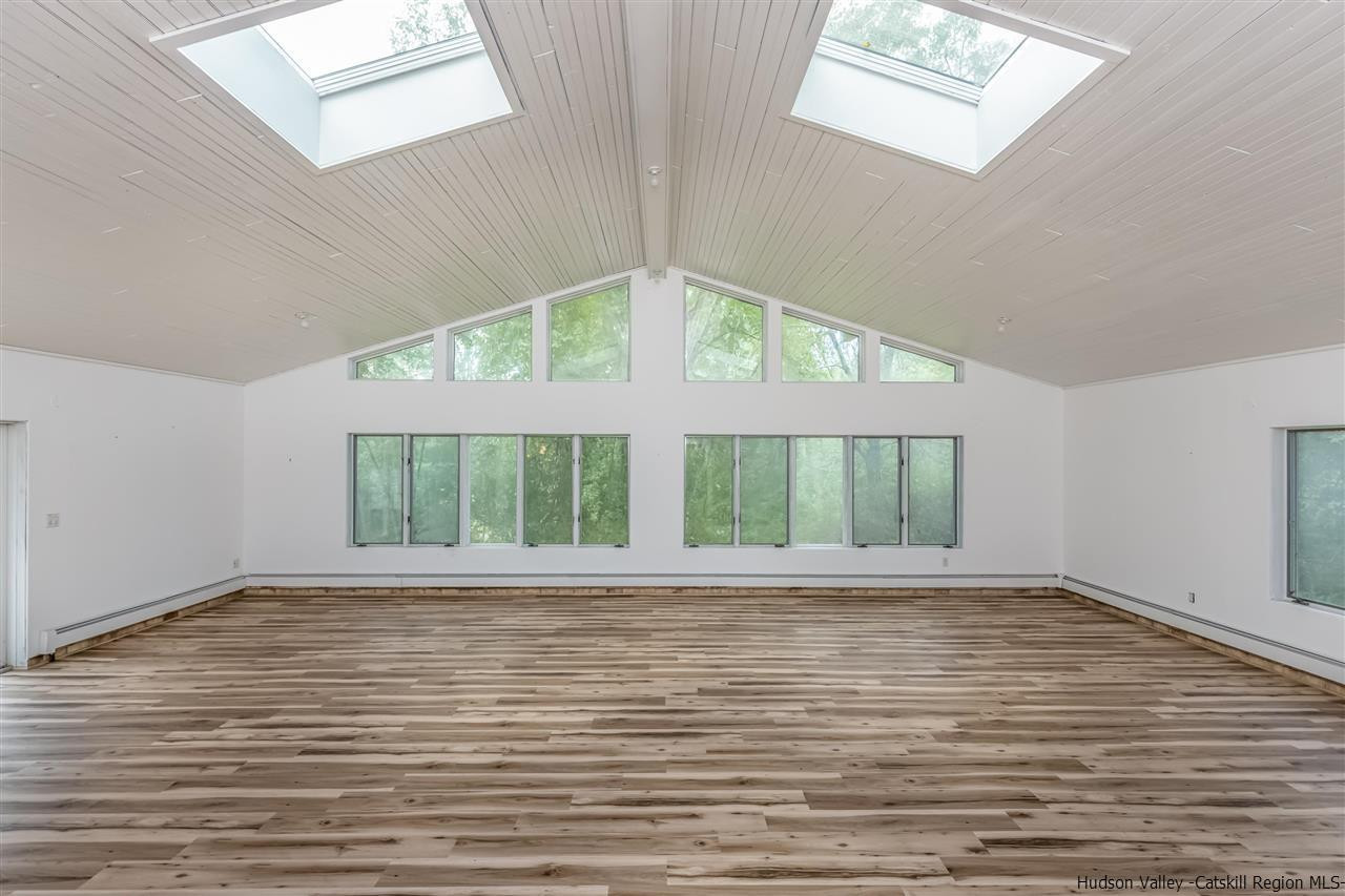 64 Buck Road Stone Ridge, NY 12484 - Photo 8 of 34 a view of an empty room with wooden floor and a window