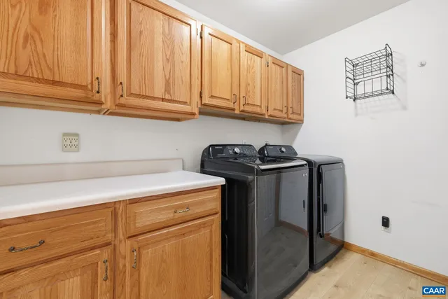 a utility room with granite countertop cabinets and washer dryer