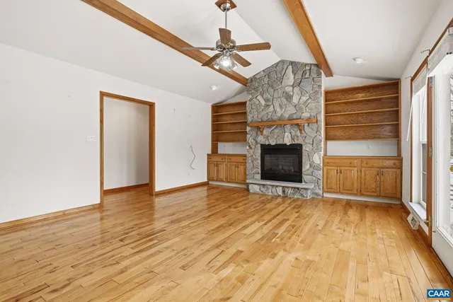a view of empty room with wooden floor and fireplace