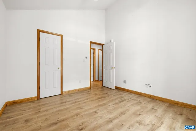 an empty room with wooden floor and closet