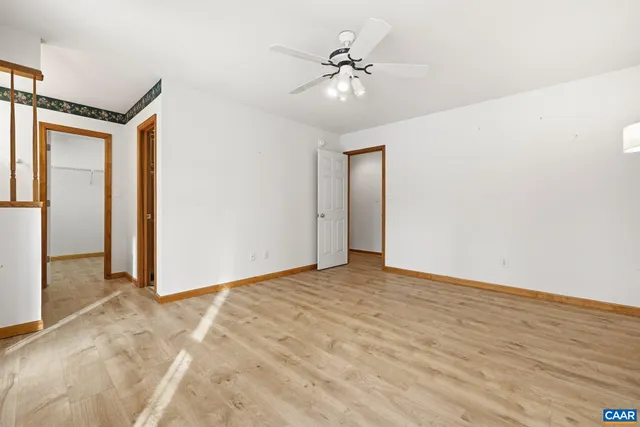 a view of an empty room with a chandelier fan