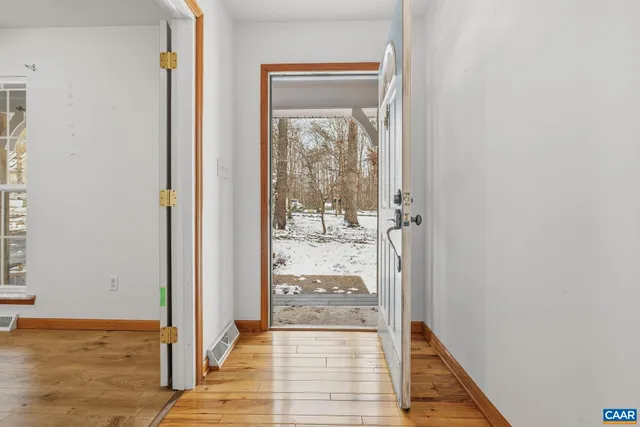 a view of a hallway with wooden floor and a livingroom