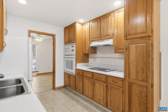 a kitchen with white cabinets and sink
