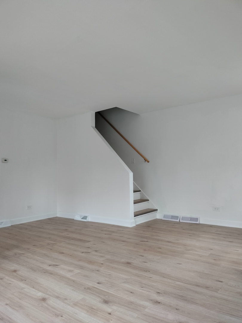 7910 South Muskegon Avenue, Unit 3 Chicago, IL 60617 - Photo 4 of 17 a view of an empty room with wooden floor