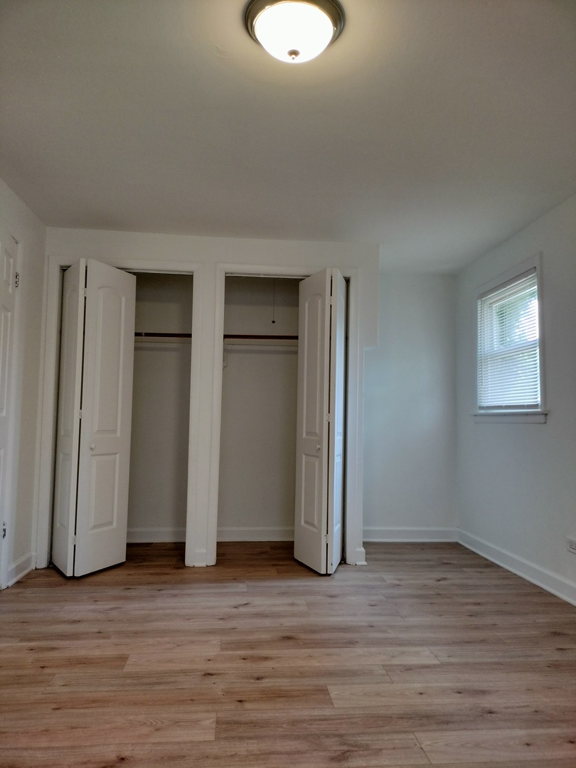 7910 South Muskegon Avenue, Unit 3 Chicago, IL 60617 - Photo 10 of 17 a view of a room with wooden floor and window
