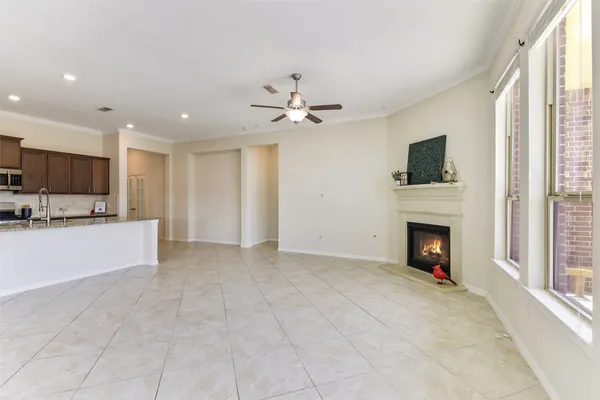 a view of an empty room with a kitchen and a fireplace