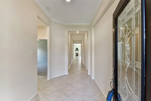 a view of a hallway with wooden floor and a bathroom