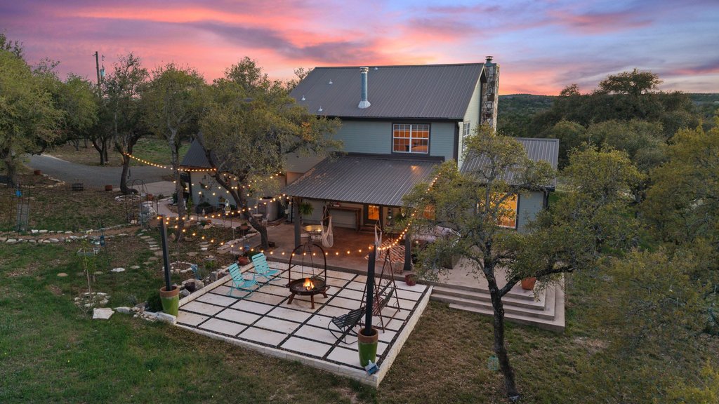 290 Sunset Ridge Dripping Springs, TX 78620 - Photo 14 of 36 An inviting backyard oasis offers a covered patio and a fire pit, perfect for evening gatherings.