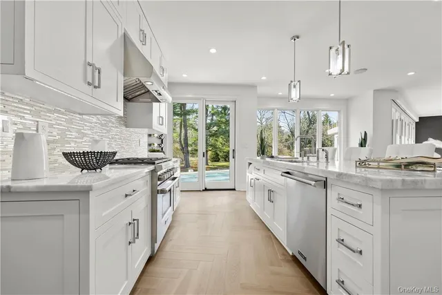 a large kitchen with stainless steel appliances kitchen island a large counter tops a stove a sink and a refrigerator