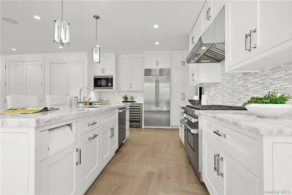 a kitchen with white cabinets and appliances