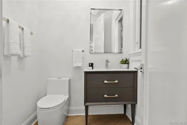 a bathroom with a toilet a sink and mirror