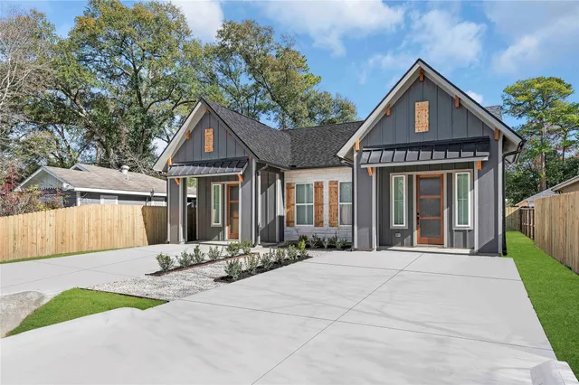 a front view of a house with a yard and potted plants