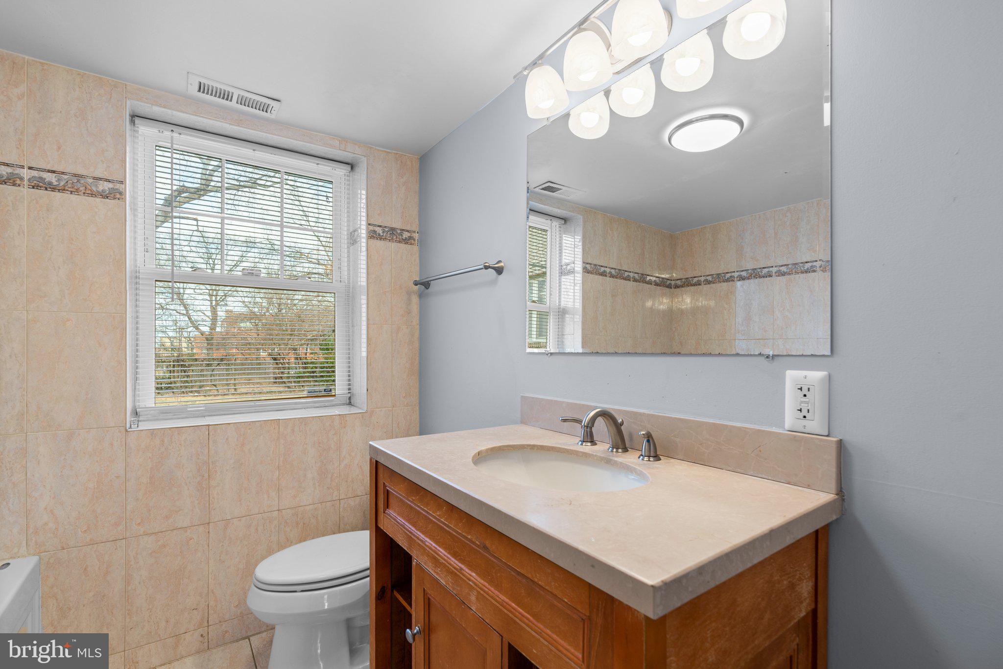 3866 9th Street Southeast, Unit 101 Washington, DC 20032 - Photo 16 of 24 a bathroom with a sink a toilet and a window