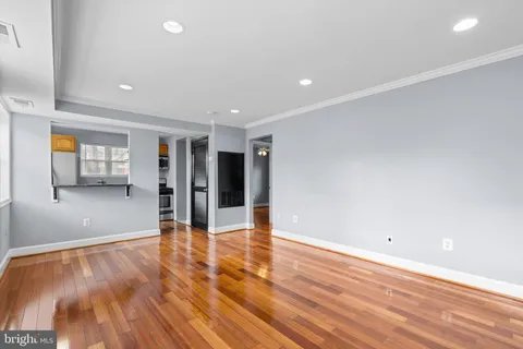 a view of an empty room with wooden floor