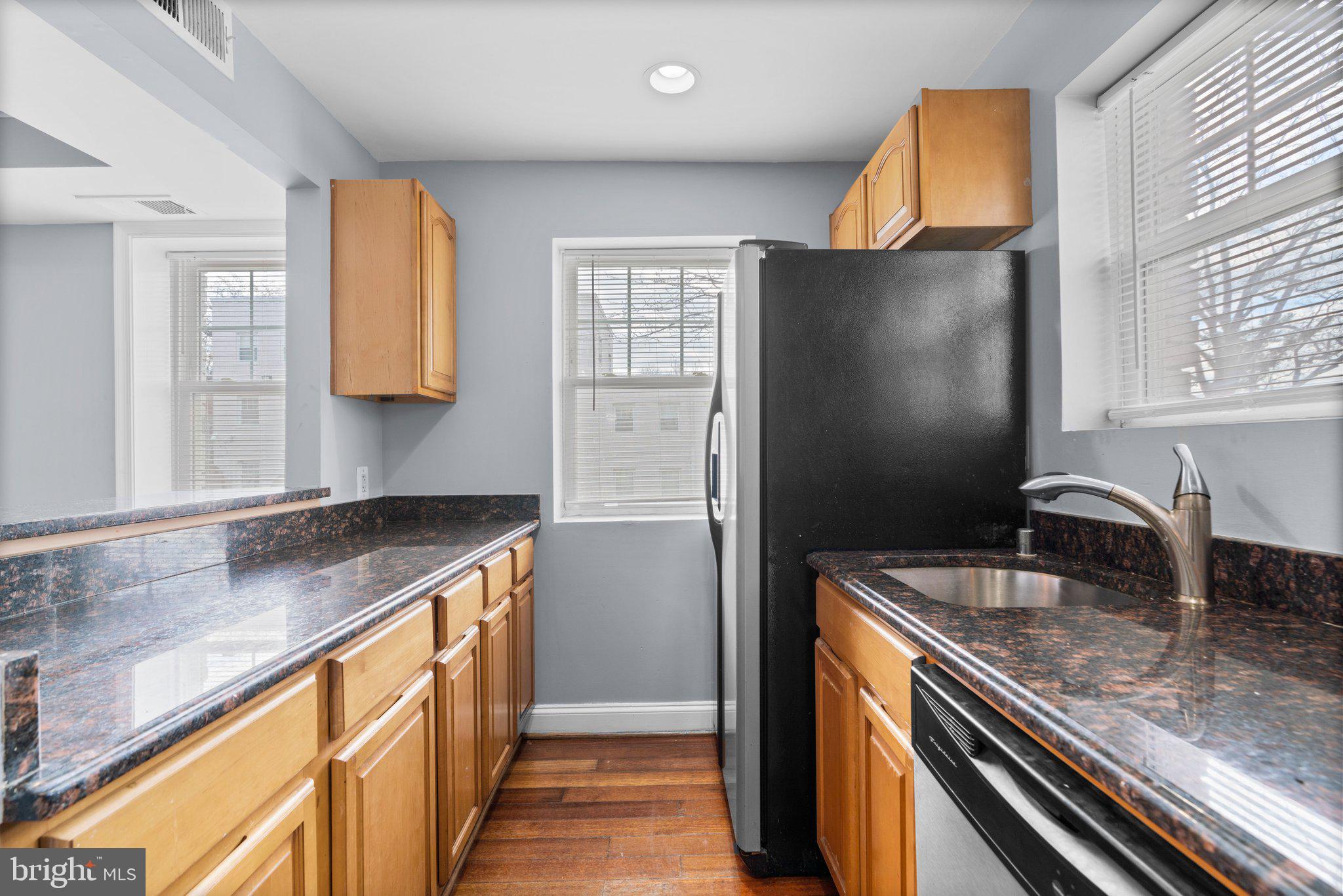 3866 9th Street Southeast, Unit 101 Washington, DC 20032 - Photo 9 of 24 a kitchen with stainless steel appliances granite countertop a sink and a refrigerator