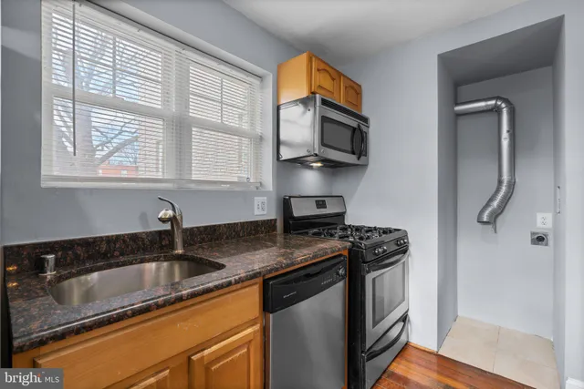 a kitchen with stainless steel appliances granite countertop a sink stove and microwave
