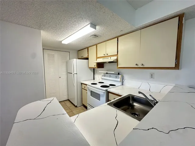 a kitchen with a sink a stove and refrigerator