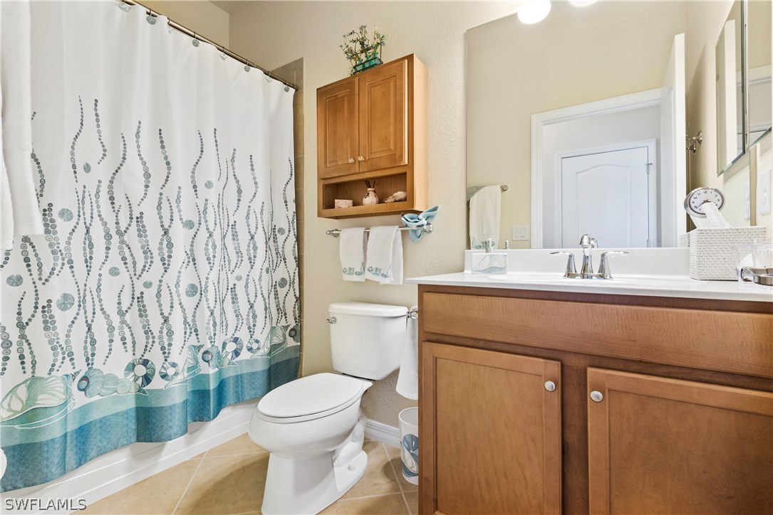 11680 Eros Road Lehigh Acres, FL 33971 - Photo 24 of 27 a bathroom with a granite countertop toilet sink and mirror