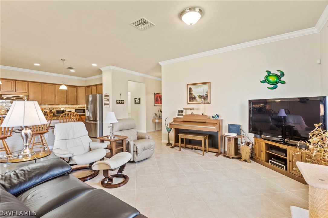 11680 Eros Road Lehigh Acres, FL 33971 - Photo 3 of 27 a living room with furniture and a flat screen tv