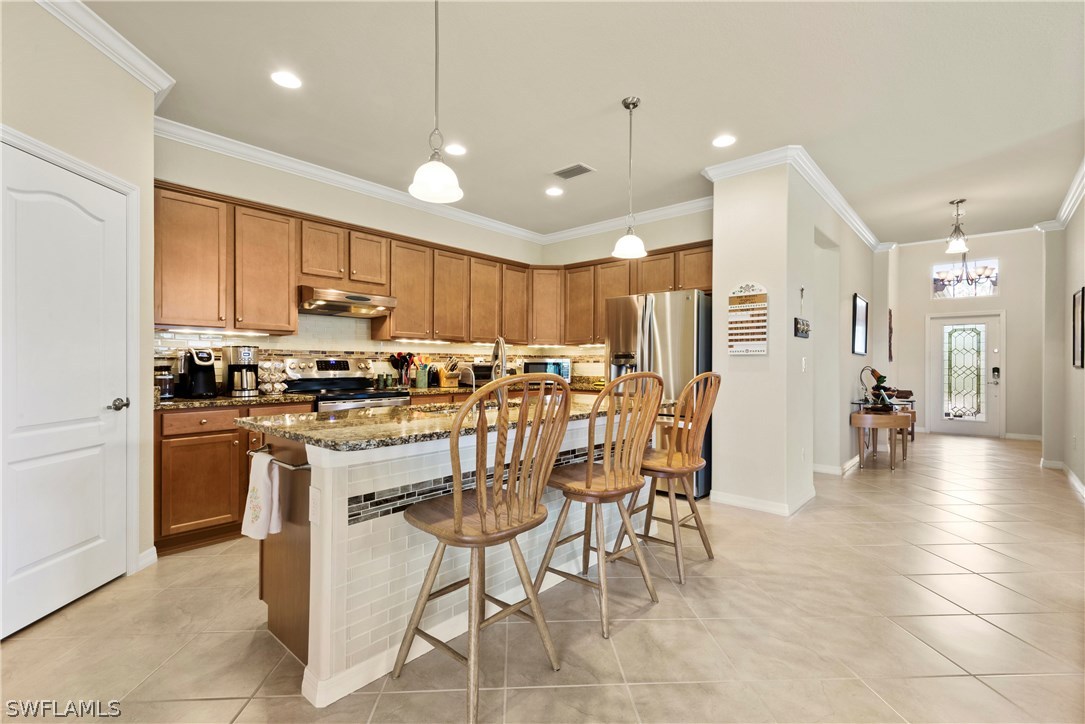 11680 Eros Road Lehigh Acres, FL 33971 - Photo 7 of 27 a kitchen with stainless steel appliances a refrigerator a stove a sink a dining table and chairs