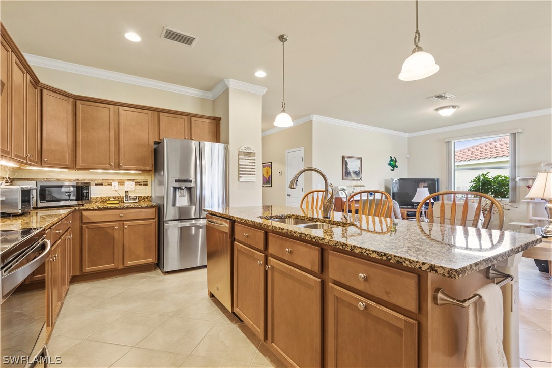 11680 Eros Road Lehigh Acres, FL 33971 - Photo 8 of 27 a kitchen with stainless steel appliances granite countertop a sink a stove and refrigerator