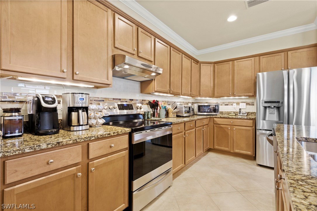 11680 Eros Road Lehigh Acres, FL 33971 - Photo 9 of 27 a kitchen with stainless steel appliances granite countertop a stove a sink and a refrigerator