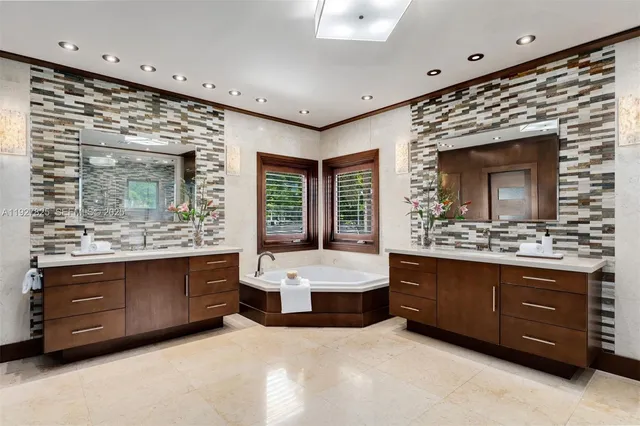 a en suite spacious bathroom with a granite countertop tub shower and mirror