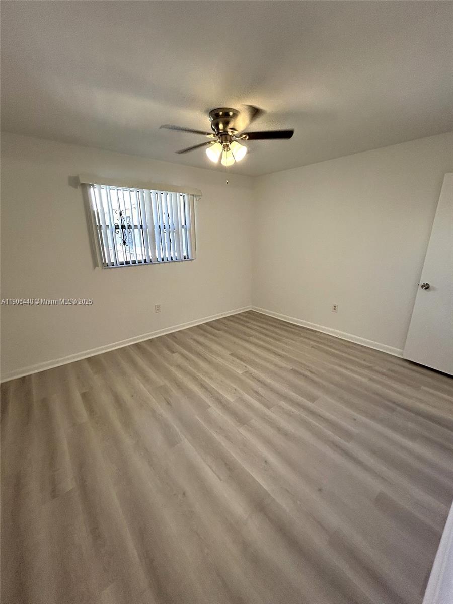 11905 Northeast 2nd Avenue, Unit C402 North Miami, FL 33161 - Photo 11 of 18 an empty room with windows and fan