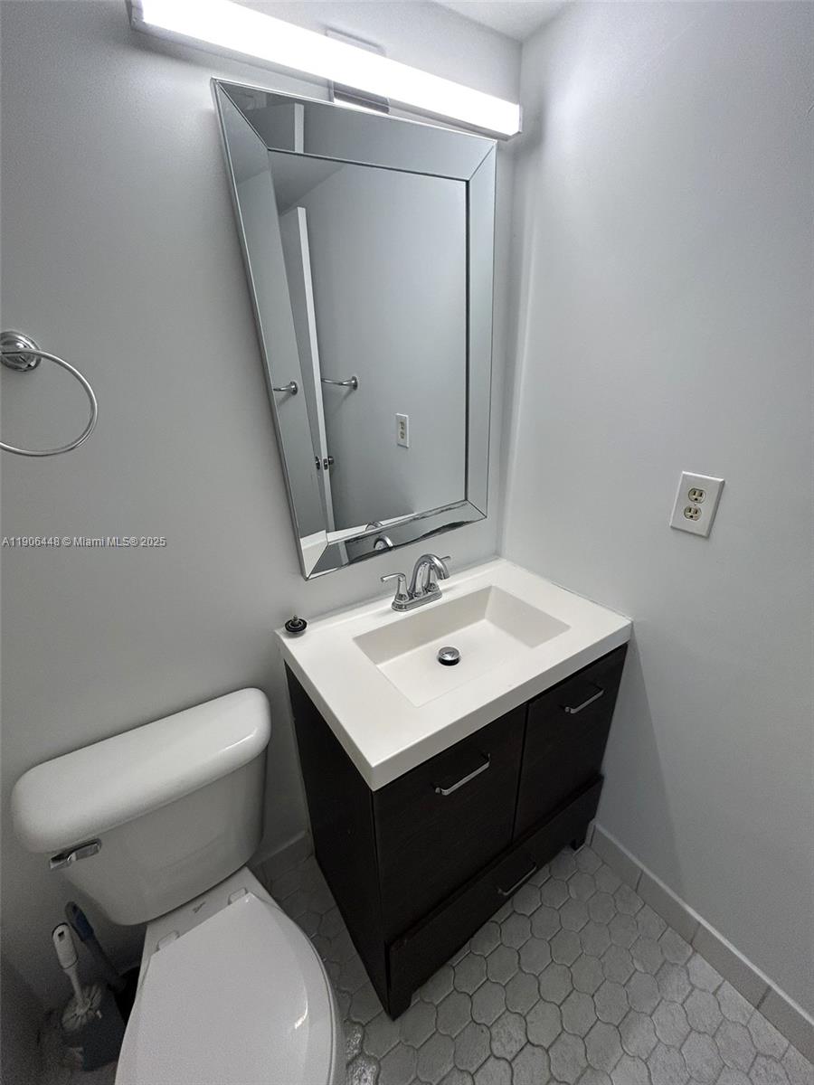 11905 Northeast 2nd Avenue, Unit C402 North Miami, FL 33161 - Photo 14 of 18 a bathroom with a sink toilet and mirror