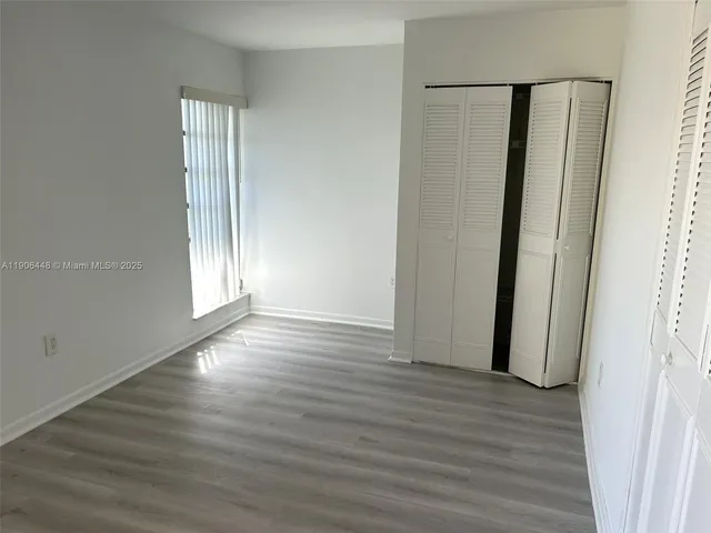 an empty room with wooden floor and entrance