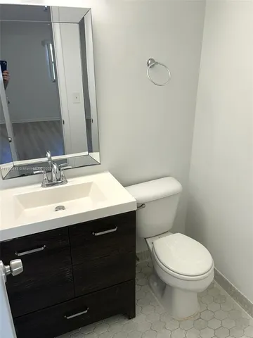 a bathroom with a sink vanity mirror and toilet