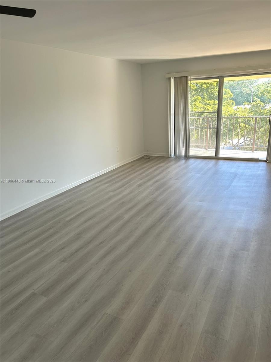 11905 Northeast 2nd Avenue, Unit C402 North Miami, FL 33161 - Photo 6 of 18 a view of an empty room with wooden floor and a window