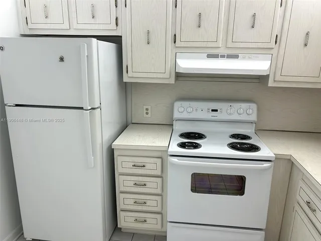 a kitchen with refrigerator a stove a microwave and cabinets