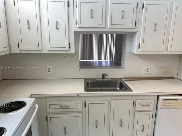 a kitchen with white cabinets and white appliances