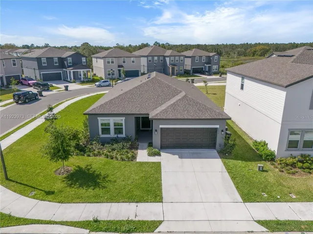 a aerial view of a house with a garden and lake view
