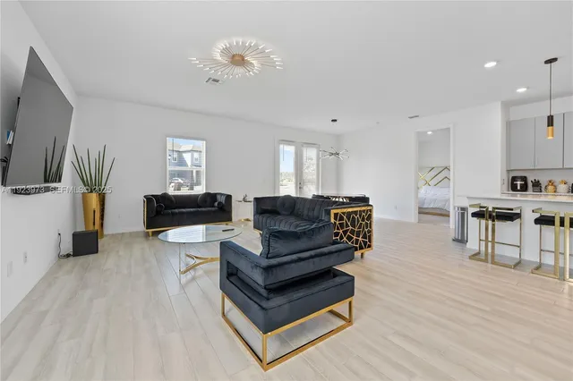 a living room with furniture and a wooden floor