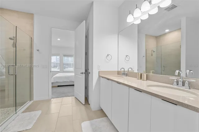 a en suite bathroom with a granite countertop sink a toilet and a mirror