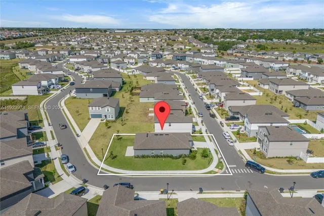 an aerial view of residential houses with outdoor space and parking
