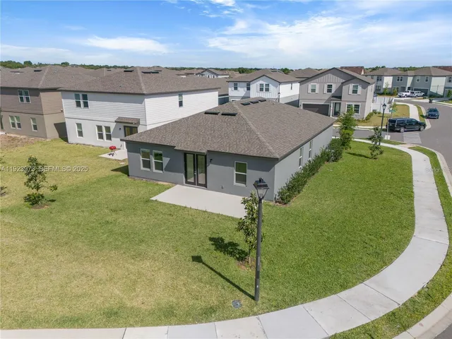 a view of a white house with a swimming pool and outdoor seating