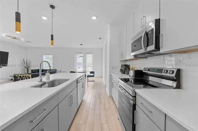 a kitchen with stainless steel appliances granite countertop a sink and stove top oven